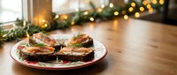 Festive holiday appetizers with smoked salmon on dark bread served on decorative plate with Christmas lights and garland creating warm seasonal atmosphere.