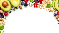 Healthy organic food frame with fresh fruits, nuts, seeds and berries on white background. Clean eating concept for nutrition and wellness lifestyle.