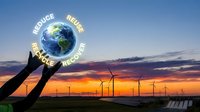 Hands reaching toward Earth globe with sustainability words against wind turbines and solar panels at sunset for environmental awareness campaigns.
