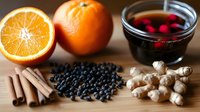 Warming winter spices and ingredients including orange, elderberries, cinnamon, ginger and mulled wine for seasonal cooking and natural remedies.