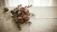 Dusty pink rose bouquet with eucalyptus and lace ribbon on linen, vintage romantic style for wedding, event, or floral design inspiration.