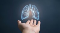 Glowing digital lungs hologram floating above open hand against dark background, representing respiratory health, medical technology, and healthcare innovation for digital medicine concepts.
