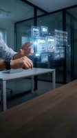 Businessman touching holographic digital interface with calendar, video, charts and analytics icons in modern office workspace for business technology concepts.
