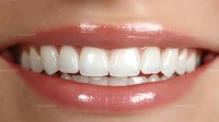 Close up of healthy white teeth and pink glossy lips showing natural smile, dental care and oral hygiene concept for dentistry and cosmetic services.