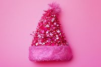 Pink winter knitted hat decorated with sequins and pom pom on pink background, festive holiday fashion accessory isolated for design use.