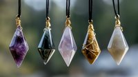 Crystal pendants with amethyst, smoky quartz, rose quartz, citrine and moonstone hanging on black cords against blurred natural background for spiritual jewelry design.