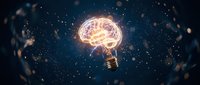 Human brain inside glowing light bulb floating in cosmic space with stars and particles, representing creativity, innovation, intelligence and bright ideas.