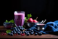 Purple berry smoothie with fresh blueberries, strawberries and mint leaves on wooden table. Healthy breakfast drink with antioxidant fruits for nutrition.