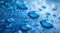 Water droplets on blue waterproof surface showing hydrophobic effect with macro detail of beaded moisture and condensation.