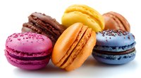 Colorful French macarons with different flavors and fillings arranged on white background, isolated confectionery close up shot for food photography and menu design.