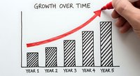 Hand drawing red growth arrow on business chart showing 5-year progress with striped bars. Concept for financial success, business development and strategic planning.