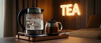 Boiling glass electric kettle and teapot with brewed tea on wooden tray, glowing TEA neon sign in cozy hotel room background.