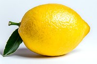 Fresh yellow lemon with green leaf isolated on white background, showing natural texture and vibrant color. Suitable for food, cooking, and healthy lifestyle designs.