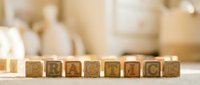 Wooden alphabet blocks spelling PRACTICE arranged in row on table with blurred background for educational learning and skill development concepts.