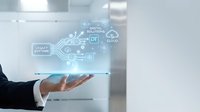 Businessman in dark suit and white shirt holding digital technology interface with circuit board design, cloud computing icons, and data solutions symbols in modern office environment.