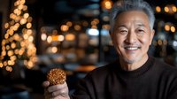 Smiling senior Asian man holding traditional mooncake during Mid-Autumn Festival celebration with warm bokeh lights background for holiday marketing materials.