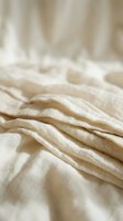 Crumpled beige linen fabric with soft folds and natural texture, suitable for home decor, textile design, and interior styling projects.