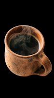 Rustic clay mug with steaming black coffee, isolated on transparent background. Ready for t-shirt design, stickers, print on demand, sublimation, and clipart use.