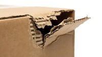 Torn cardboard box edge showing corrugated layers and damage, suitable for packaging, shipping, recycling, and waste management concepts.