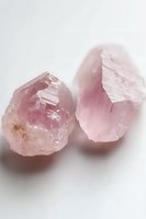 Raw rose quartz crystals on white background showing natural mineral formation and pink hues, suitable for wellness and spiritual concepts.