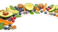 Healthy superfood ingredients with avocado, nuts, berries and vegetables arranged on white background for clean eating and nutrition concepts.