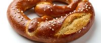 Freshly baked pretzel with coarse salt crystals on white background, ready for bakery, food service, or culinary design projects.
