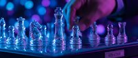 Glass chess set with glowing blue and purple neon lights creating strategic gaming atmosphere for business concepts and intellectual competition.