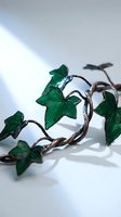 Decorative vine with translucent emerald star-shaped leaves on twisted brown stem, isolated on white background for design projects and botanical artwork applications.
