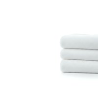 Stack of three folded white cotton towels on clean background for bathroom decor, spa treatments, hotel amenities and home textile advertising.