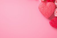 Romantic pink background with glittery red hearts and delicate rose flowers in corner, creating soft Valentine's Day or love-themed composition with copy space.