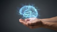 Glowing blue brain hologram floating above open human hands on dark background representing artificial intelligence and mental health concepts.