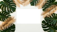 Tropical frame with golden palm leaves and green monstera foliage surrounding white blank space for text or design elements on neutral background.
