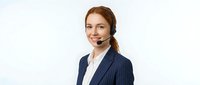 Professional young Caucasian businesswoman with headset smiling at camera in navy pinstripe suit jacket on white background for customer service concepts.
