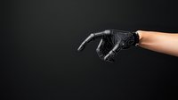 Futuristic black robotic prosthetic arm reaching forward against dark background, demonstrating advanced bionic technology and human-machine integration.