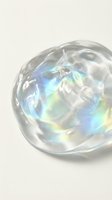Iridescent soap bubble with rainbow reflections floating on neutral background showcasing prismatic light effects and translucent spherical form.