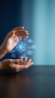 Hands holding glowing scientific and technological icons including atoms, molecules, and data charts against blue gradient background for research and innovation concepts.