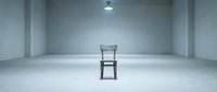 Empty minimalist room with single wooden chair centered on concrete floor under overhead lighting, suitable for conceptual, editorial, and commercial design projects.