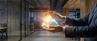 Businessman hands protecting glowing house model in modern office space representing real estate investment protection and property insurance concept.