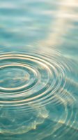 Tranquil water surface with gentle ripples and circular waves reflecting soft sunlight creating peaceful aquatic patterns for meditation and wellness content.