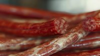 Close-up of cured meat sticks showing detailed texture and marbling, suitable for food photography, culinary content, restaurant menus, and gourmet food marketing materials.
