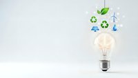 Glowing light bulb with green energy icons including recycling symbols, leaf, water drop and wind turbine representing sustainable innovation concepts.