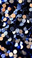 Glowing blue and white bokeh lights create magical sparkle effect against dark background, with soft circular blurs creating dreamy atmospheric mood.