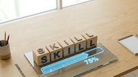 Professional development concept with wooden letter blocks spelling SKILL on modern desk with progress bar showing 75% completion for training programs.