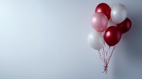 Festive bunch of burgundy, pink and white helium balloons floating against light gray background with copy space for celebration designs and party concepts.