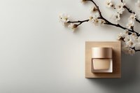 Luxury cosmetic cream jar on wooden podium with blooming cherry branches against neutral background. Minimal beauty product photography setup.