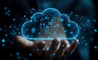 Digital cloud computing concept with glowing blue hologram floating above male hand against dark background, representing modern technology and data storage.