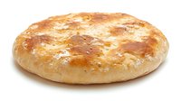 Freshly baked round flatbread with golden brown crust and soft texture isolated on white background, ready for food packaging and menu design projects.