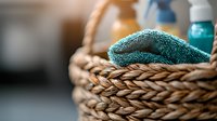 Woven seagrass basket with cleaning supplies and turquoise microfiber cloth, natural eco-friendly home organization and housekeeping essentials for sustainable living.