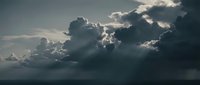 Dramatic storm clouds gathering over dark ocean waters with sunlight breaking through creating moody seascape atmosphere for weather and nature concepts.