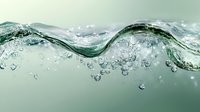 Dynamic water wave with bubbles and splashes creating curved line against mint green background, macro photography showing liquid motion and transparency.